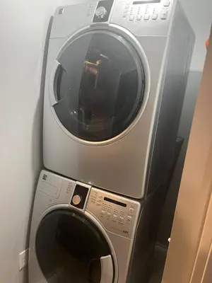 a washer and dryer sitting next to a wall at Cozy Basement Near Airport YYC in Calgary