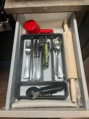 a tray with utensils in a drawer in a refrigerator at Cozy Basement Near Airport YYC in Calgary