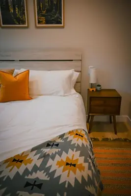 a bedroom with a bed and a table with a lamp at Courtenay Luxe Suite in Courtenay