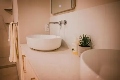 a bathroom with a white bowl sink on a counter at Courtenay Luxe Suite in Courtenay