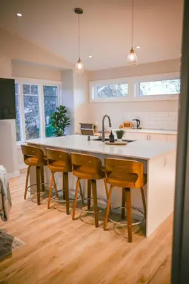 a kitchen with a large kitchen island with wooden chairs at Courtenay Luxe Suite in Courtenay
