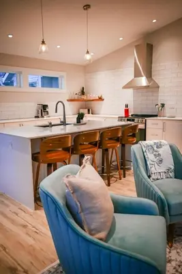 a kitchen with a blue couch with a dog laying on it at Courtenay Luxe Suite in Courtenay