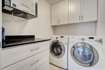 a white laundry room with a washer and dryer at D Peaceful Suite in West Vancouver