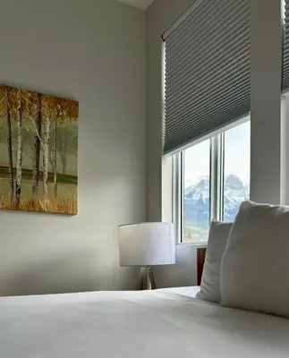 a bedroom with a bed and a window with a blind at Canmore Mountain View Escape in Canmore