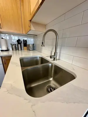 a stainless steel sink in a white kitchen at Canmore Mountain View Escape in Canmore