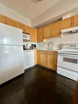 a kitchen with white appliances and wooden cabinets at Canmore Mountain View Escape in Canmore