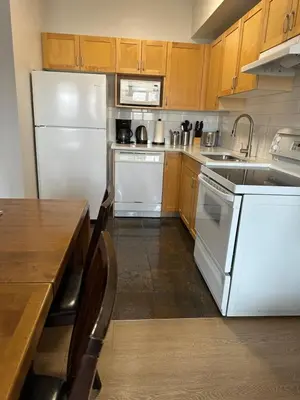 a kitchen with white appliances and wooden cabinets at Canmore Mountain View Escape in Canmore