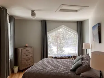 a bedroom with a bed and a large window at Tamarack Suite in Golden
