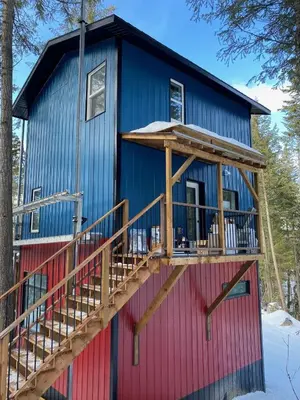 a blue and red house with a deck at Tamarack Suite in Golden