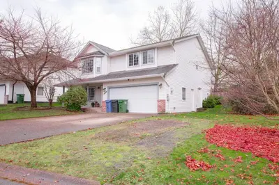 a white house with a garage and a driveway at The Vida 1 Bed Pet-Friendly in Abbotsford
