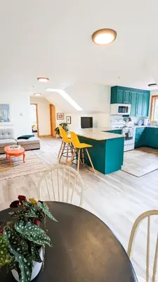 a kitchen with green cabinets and a table and chairs at Quirky Farm Stay at Flower Beds Farm - Hot Tub in Qualicum Beach