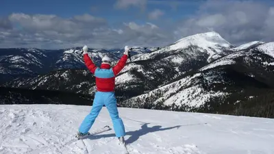 a person on skis standing on top of a snow covered mountain at Fresh Studio Apartment in Central Rossland in Rossland