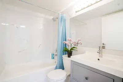 a white bathroom with a toilet and a sink at Yaletown Gorgeous Unit Steps from the Beach in Vancouver