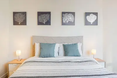 a bedroom with a bed with four pictures on the wall at Yaletown Gorgeous Unit Steps from the Beach in Vancouver