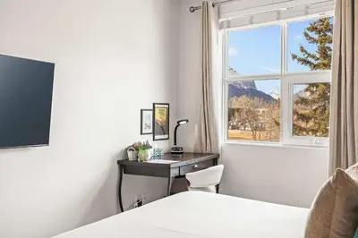 a bedroom with a desk and a window at Charming & Cozy 1-Bedroom Retreat in Canmore