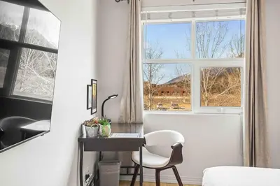 a bedroom with a desk and a window at Charming & Cozy 1-Bedroom Retreat in Canmore