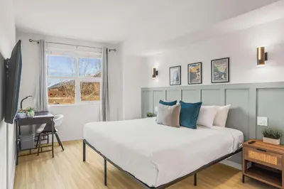 a bedroom with a large white bed and a desk at Charming & Cozy 1-Bedroom Retreat in Canmore