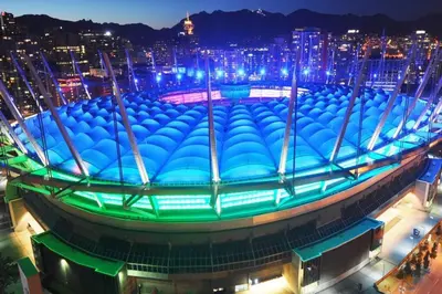 a large blue building with a city at night at Home in the Sky with Gorgeous Water Views in Vancouver