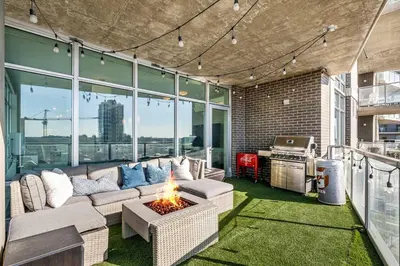 a living room with a couch and a fire pit at Urban Oasis - 2BR Condo Downtown Large Balcony in Calgary