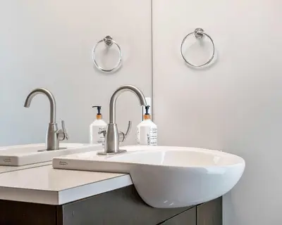a bathroom with two sinks and two mirrors at Urban Oasis - 2BR Condo Downtown Large Balcony in Calgary