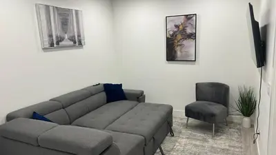 a living room with a couch and a chair at Private Very Spacious 2 bed 1-Bedroom basement Suite SW Calgary in Calgary