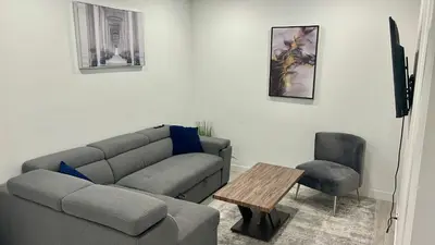 a living room with a couch and a table at Private Very Spacious 2 bed 1-Bedroom basement Suite SW Calgary in Calgary