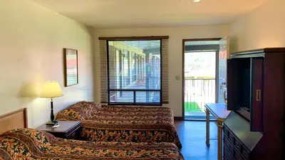 a hotel room with two beds and a television at Hotel viewmont in Logan Lake