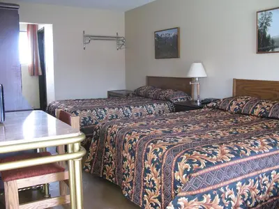 a hotel room with two beds and a table at Hotel viewmont in Logan Lake