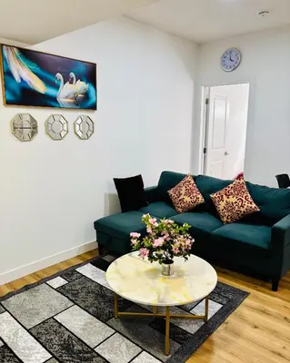 a living room with a blue couch and a table at Charming Stay & Cozy Retreat by Bansari Homes in Edmonton- YEG in Edmonton