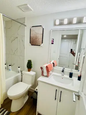 a white bathroom with a toilet and a sink at Charming Stay & Cozy Retreat by Bansari Homes in Edmonton- YEG in Edmonton