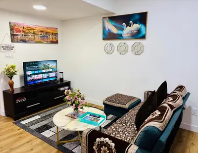 a living room with a couch and a tv at Charming Stay & Cozy Retreat by Bansari Homes in Edmonton- YEG in Edmonton