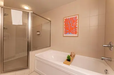 a bathroom with a shower and a bath tub with a sink at Breathtaking Luxury 3Bd Penthouse Pool and Hot Tub in Canmore