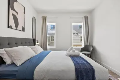a bedroom with a large bed with a teddy bear on it at Luxury Aspen 2BR Home with Double Garage Car Parking in Calgary