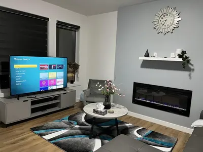 a living room with a flat screen tv and a table at Elegant 3BD Home in Beaumont, Double Garage in Nisku