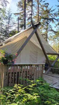 a white tent on a wooden fence with flowers at Haida Gwaii Glamping in Tlell