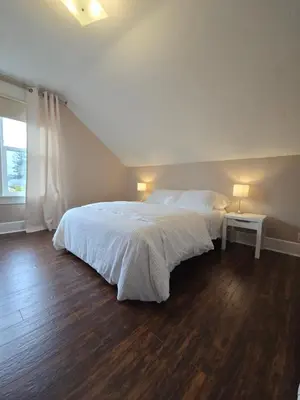 a bedroom with a large white bed and a window at Two bedroom coastal retreat in Victoria