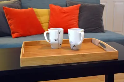 two coffee mugs sitting on a wooden tray on a table at Calm, cozy, urban, family-friendly stay in Vancouver