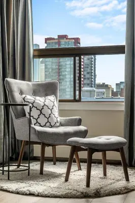 a chair and stool in a room with a window at Winter Prices Reduced for Stylish Condo & Easy to Mountains ! in Calgary