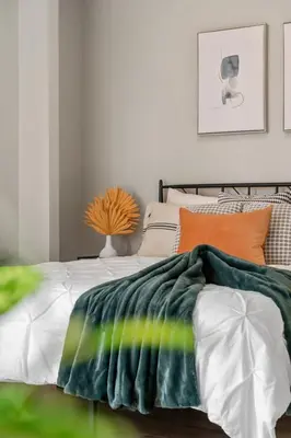 a bedroom with a bed with a green blanket on it at Winter Prices Reduced for Stylish Condo & Easy to Mountains ! in Calgary