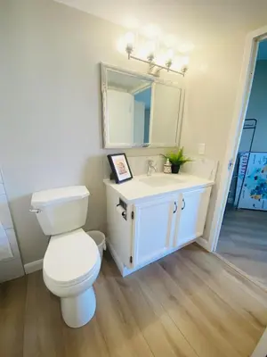 a bathroom with a white toilet and a sink at Winter Prices Reduced for Stylish Condo & Easy to Mountains ! in Calgary