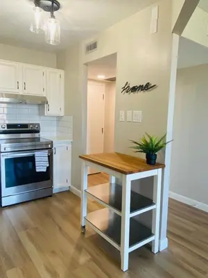 a kitchen with a table and a stove at Winter Prices Reduced for Stylish Condo & Easy to Mountains ! in Calgary