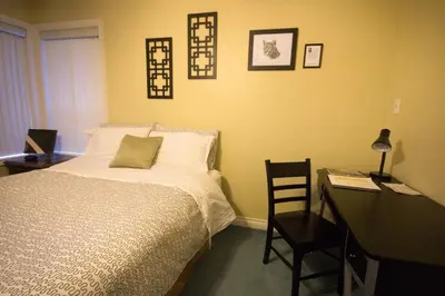 a bedroom with a bed and a desk with a desk at Eagle Close Executive B&B in Prince Rupert