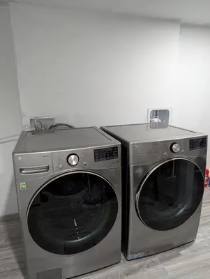 two washing machines are sitting next to each other at MIAT Apartment in Calgary