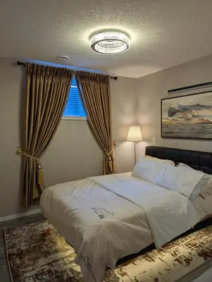 a bedroom with a large bed and a window at MIAT Apartment in Calgary