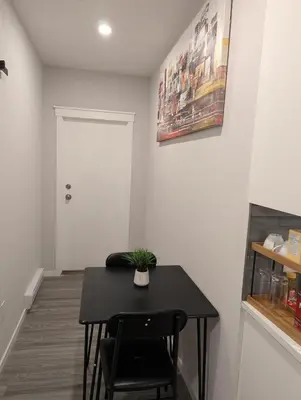 a small black table in a room with a plant on it at MIAT Apartment in Calgary