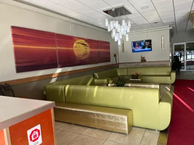 a waiting room with a green leather couch at The Lodge Inn in Edmonton