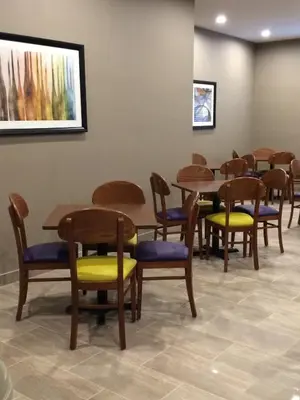 a waiting room with wooden tables and chairs at Meridian Inn & Suites Lloydminster in Lloydminster