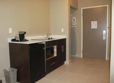 a kitchen with a sink and a microwave at Meridian Inn & Suites Lloydminster in Lloydminster