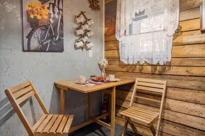 a wooden table with two chairs and a table with cups on it at Rustic Cozy Cabin with hot tub in Bragg Creek