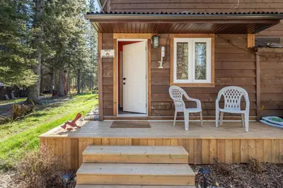 a tiny house with two chairs and a door at Shanti Yurt with private hot tub in Bragg Creek in Bragg Creek